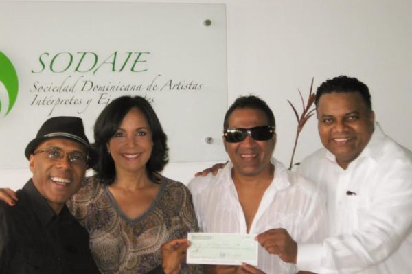 Momentos en que los ejecutivos de SODAIE, Pochy Familia y Ramón Orlando Valoy entregan los cheques que corresponden a Kinito Méndez y Adalgisa Pantaleón.